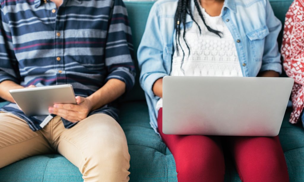 Photo of two nursing students using a laptop and a tablet