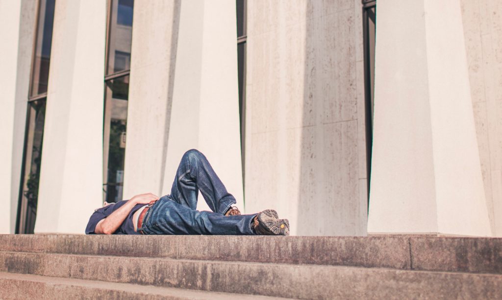 Photo of an exhausted nurse practitioner lying on the ground