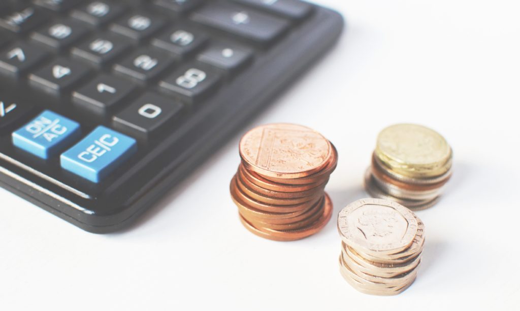 Closeup photo of stacks of coins and a calculator