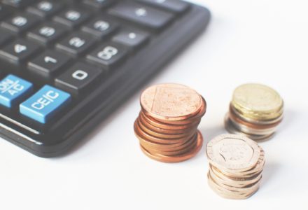 Closeup photo of stacks of coins and a calculator