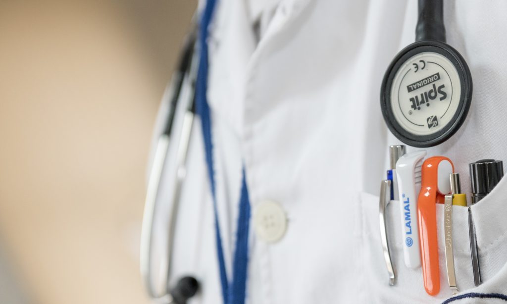 A closeup photo of a nurse practitioner wearing a lab coat