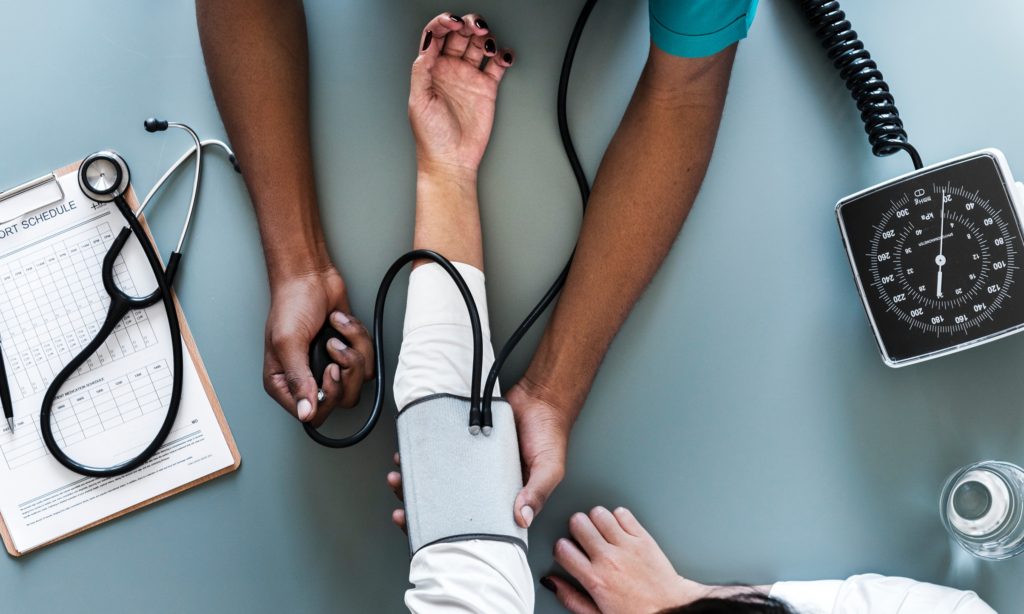 Photo of nurse practitioner who is taking a patient's blood pressure