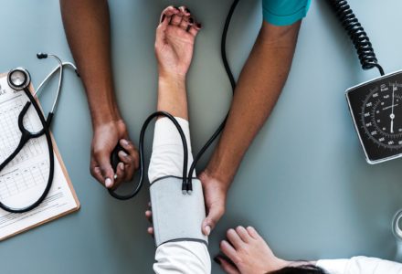 Photo of nurse practitioner who is taking a patient's blood pressure