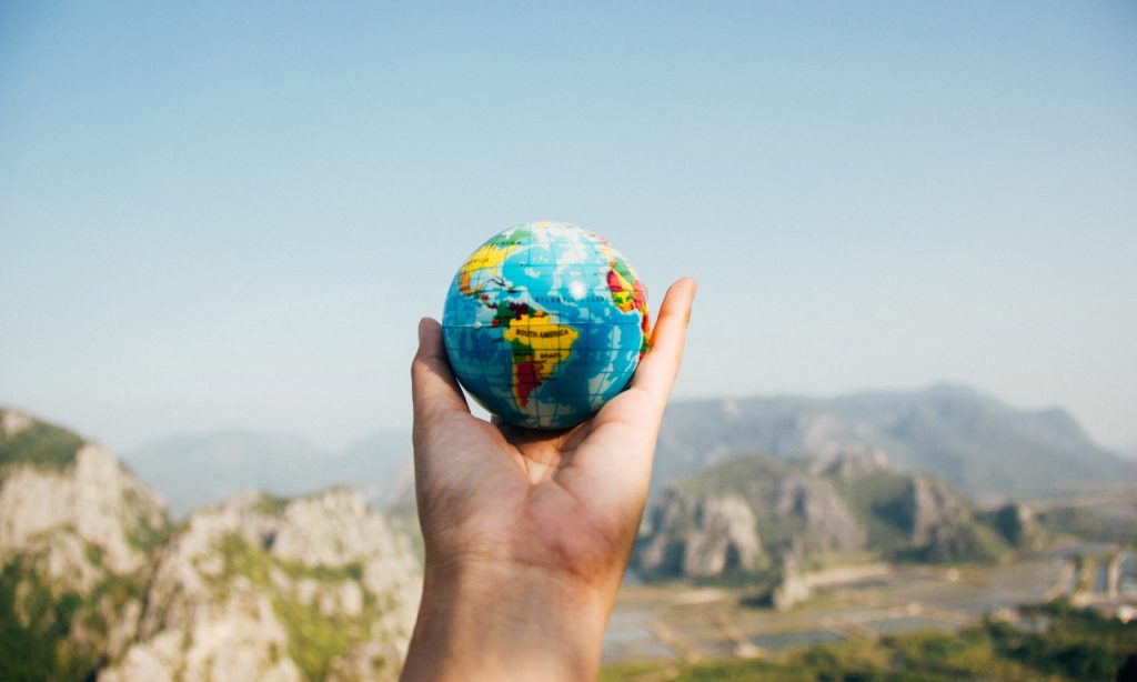 Photo of a small globe being held in the air