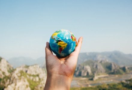 Photo of a small globe being held in the air