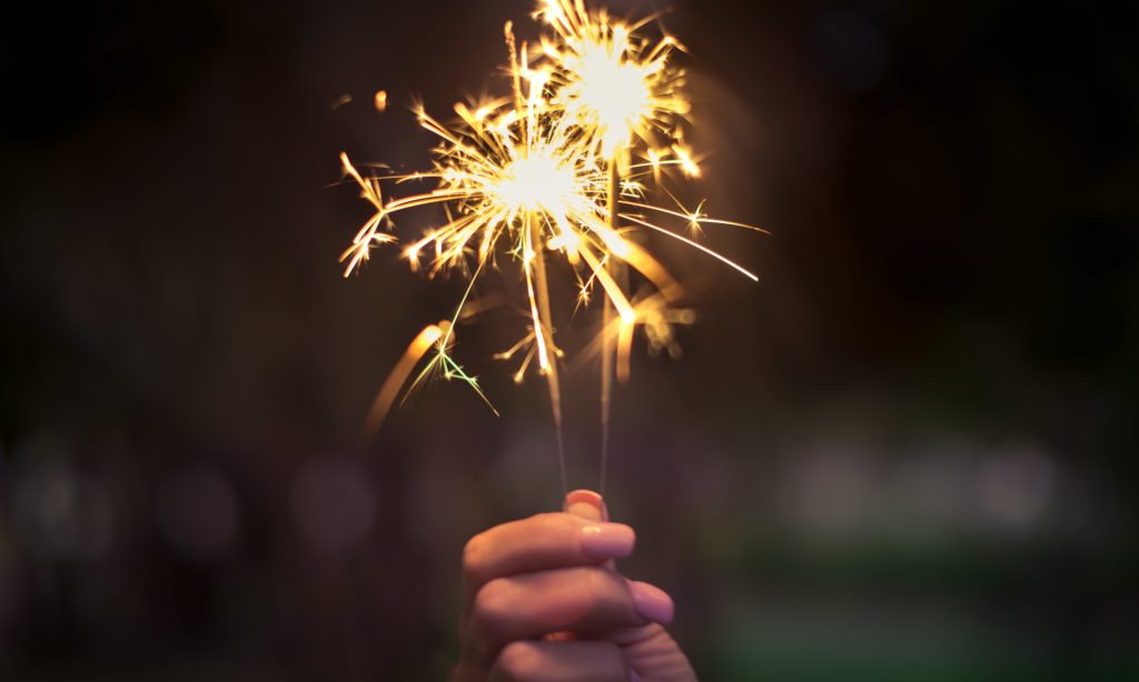 Closeup photo of a nurse practitioner holding a sparkler firework